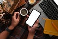 Man holding coffee cup and using smart phone at workplace. Royalty Free Stock Photo