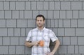 Young man holding a coffee mug with a grey neutral background.