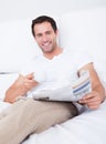 Young Man Holding Cup In Hand Reading Newspaper Royalty Free Stock Photo