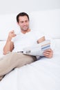 Young Man Holding Cup In Hand Reading Newspaper Royalty Free Stock Photo