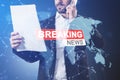 Young man holding document with creative hi-tech breaking news and globe hologram on blurry blue background with map. Television, Royalty Free Stock Photo