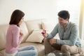 Young man holding engagement ring, making marriage proposal to g