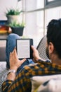 Young Man Holding Ereader And Reading Ebook