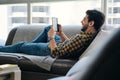 Young Man Holding Ereader And Reading Ebook