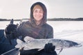 Young man holding fish catch a big pike ice fishing Royalty Free Stock Photo