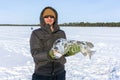 Young man holding fish catch a big pike ice fishing Royalty Free Stock Photo