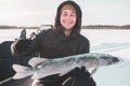 Young man holding fish catch a big pike ice fishing Royalty Free Stock Photo