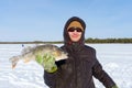 Young man holding fish catch a big pike ice fishing Royalty Free Stock Photo