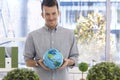 Young man holding globe smiling Royalty Free Stock Photo