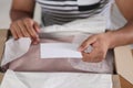 Young man holding greeting card near parcel with Christmas gift, closeup Royalty Free Stock Photo