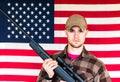 Young Man Holding Gun on American Flag Background