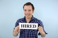 Young man holding hired sign