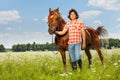 Young man holding his brown horse by a bridle Royalty Free Stock Photo