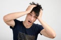 Young man holding his head frowning with worry screaming. Royalty Free Stock Photo