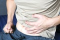 Young man holding his stomach and severe stomach pain from enteritis, food poisoning, health concept