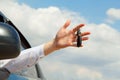 Young man holding keys remote from his car in hands over sky background Royalty Free Stock Photo