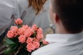 A young man is holding a large bouquet of pink roses on Women& x27;s Day. Fresh rose flowers. Royalty Free Stock Photo