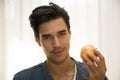 Young man holding a large delicious ripe apple