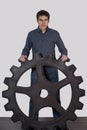 Young man holding a large gear