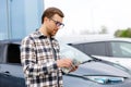 Young man holding money in hand standing front car and prepare pay by installments - insurance, loan and buying car concept Royalty Free Stock Photo