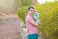 Young man holding a newborn baby in his arms on the summer background. Newborn photosession. Family portrait. Father and his son. Royalty Free Stock Photo