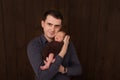 Young man holding a newborn baby in his arms on the white background. Newborn photosession. Family portrait. Father and his son. B Royalty Free Stock Photo