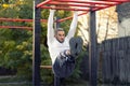 Young man holding onto a horizontal ramp working out his frontal abs, abs workout with horizontal ladder Royalty Free Stock Photo