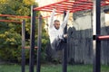 Young man holding onto a horizontal ramp working out his frontal abs, abs workout with horizontal ladder Royalty Free Stock Photo