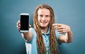 Young man holding out a cellphone Royalty Free Stock Photo