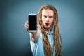 Young man holding out a cellphone Royalty Free Stock Photo