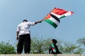 a young man holding a Palestinian flag