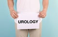 Young man holding paper with word UROLOGY