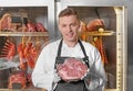 Young man holding piece of raw meat in butcher shop Royalty Free Stock Photo