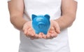 Young man holding piggy bank on background, closeup Royalty Free Stock Photo