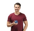 Young man holding piggy bank on white background. Money savings concept Royalty Free Stock Photo