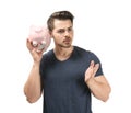 Young man holding piggy bank on white background. Money savings concept Royalty Free Stock Photo