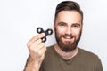 Young man holding and playing with fidget spinner. Royalty Free Stock Photo