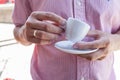 Young man holding porcelain cup with his morning espresso. Close