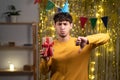 Young man holding present with angry face, negative sign showing dislike with thumbs down, rejection concept Royalty Free Stock Photo