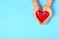 Young man holding red heart on light blue background, top view with space for text. Royalty Free Stock Photo