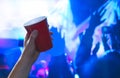 Young man holding red party cup in nightclub dance floor. Alcohol container in hand in disco. Royalty Free Stock Photo