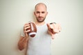 Young man holding rugby american football ball over isolated background pointing with finger to the camera and to you, hand sign, Royalty Free Stock Photo