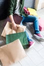 Young man holding shopping bags while resting and sitting on floor Royalty Free Stock Photo