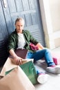 Young man holding shopping bags while resting and sitting on floor Royalty Free Stock Photo