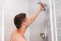 Young man holding shower head with flowing water Royalty Free Stock Photo