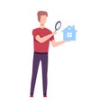 Young Man Holding Small House and Looking at it Through Magnifying Glass, Man Choosing Real Estate for Buying or Renting Royalty Free Stock Photo