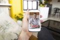 Young man holding smartphone making video call with doctor at home