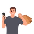 Young man holding smartphone and shopping bag