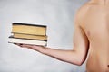Young man holding stack of books. Royalty Free Stock Photo