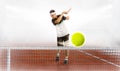 Young man holding tennis racket and ball while training